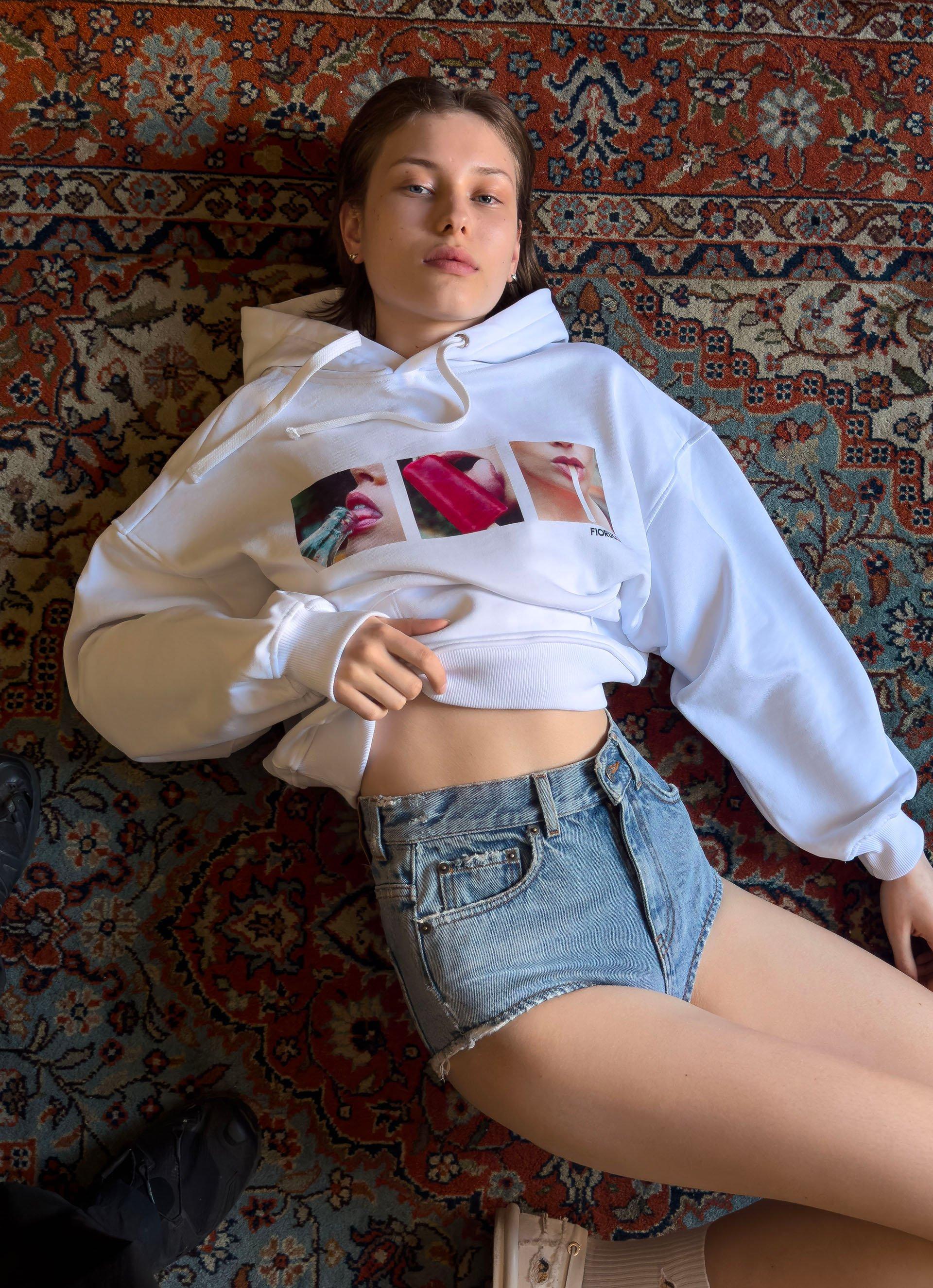 Model wears the Popsicle Hoodie in White and the Denim Hot Pant Shorts in Light Blue.